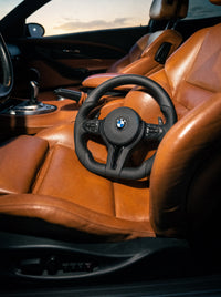 Volante deportivo de cuero M para BMW sobre el asiento de un BMW