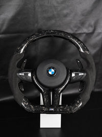 Volante BMW de fibra de carbono forjada negra sobre peana