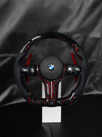 Volante BMW de fibra de carbono forjada roja con airbag sobre peana