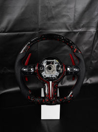 Volante BMW de fibra de carbono forjada roja sobre peana