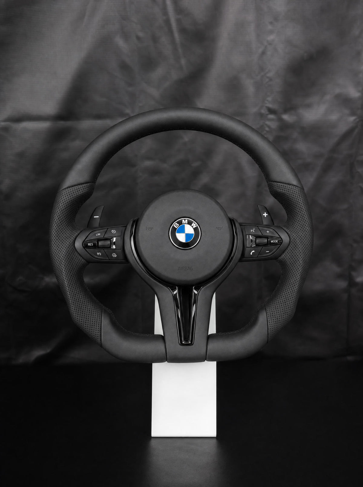 Volante deportivo de cuero M para BMW sobre peana