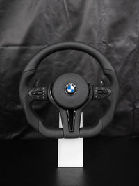 Volante deportivo de cuero M para BMW sobre peana