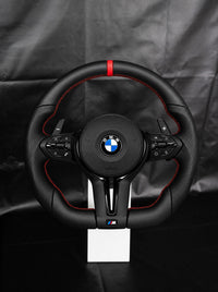 Volante BMW de cuero con franja y costura rojas sobre peana